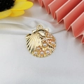 Detail of a gold shell charm with starfish and pearls on elegant white silk background - Pearl Starfish Shell