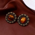 Makroaufnahme von Vintage-Ohrsteckern mit schwarz-goldener Harzoberfläche - Goldschwarz mit Bernsteinbraun