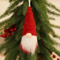 Dettaglio macro dello gnomo di Natale appeso con cappello rosso a maglia e barba di pelliccia - Pendaglio in Maglia Rosso Stile C