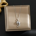 Detalle macro del colgante de delfín plateado con circonitas en caja de joyas - Plata-Doble Delfines