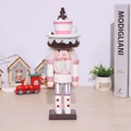 Pink nutcracker soldier doll with dessert hat on a warm Christmas themed background - 26cm Pink Cake Man