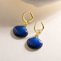 Dettaglio ravvicinato di orecchini a cerchio placcati oro 18K con ciondoli a conchiglia - Blu