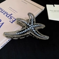 Elegante molletta per capelli a stella marina con perle blu e cristalli su un libro - Stella marina canna di fucile con perla blu / Canna di Fucile