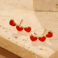 Three red velvet heart earrings with gold trim arranged on a textured stone base - Triple Red Hearts (3216)