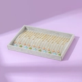 Gray velvet tray displaying assorted gold enamel necklaces with fox and clover pendants - Gray