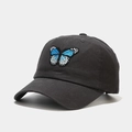 Détail de la broderie papillon bleue et blanche sur une casquette en coton gris foncé - Réglable / Gris