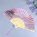 Elegant purple folding fan with landscape print, bamboo ribs and matching tassel - Peach Blossom Pavilion