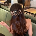 Vintage leopard print bow hair ring with crystals shown on a model in a cafe setting - Leopard Print