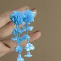 Handheld close-up of blue fabric flower tassel drop earrings - 36# Silver Needle Style