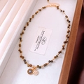 Dettaglio della collana di perle occhio di tigre placcata oro 18k con doppio ciondolo - Oro Caffè (Placcato Oro Vero)