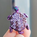 Detailed close-up of a purple turtle brooch featuring crystal rhinestones and blue gem eyes - Purple