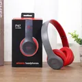 Detailopname van grijze en rode P47 draadloze hoofdtelefoon op bureau met verpakking - Rood