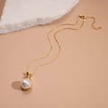 Close-up of a gold pearl pendant necklace with sparkling zircon details on a stone - Gold