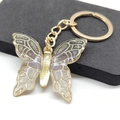 Macro shot of gold butterfly keychain with sparkling resin and translucent glitter detail - Black