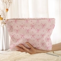 Pink corduroy makeup pouch with bow and heart print held by a model in soft light - Pink Bow Heart (LD210968)