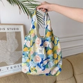 Borsa tote floreale in tessuto stropicciato tenuta da modella in ambiente moderno - Giardino di Monet Blu Giallo