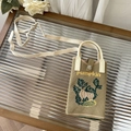 Detail of a khaki knitted pumpkin crossbody bag with U-shaped handles on a glass table - Khaki Pumpkin - Phone Bag