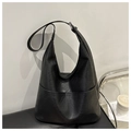 Dettaglio borsa tote nera in ecopelle grana litchi con doppie tasche su una panca - Nero