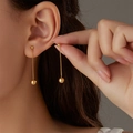 Close-up of elegant gold long chain tassel earrings with ball pendants on model - Gold Bead Fine Chain Ear Threader Style (E1637-GO)