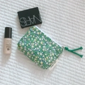 Flat lay of a floral cotton mini pouch with zipper and green tassel for makeup storage - Green Round Small Flower