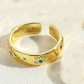 Close-up of gold-plated evil eye ring with blue enamel and clear cubic zirconia details - White