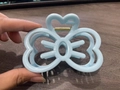 Sky blue bow-shaped hair claw clip with heart detail held in hand on dark wood background - Sky Blue