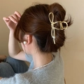 Detail of a gold bow-shaped metal hair claw clip with pearl on a woman's hair - Gold Butterfly with Artificial Pearl (FJ1315)