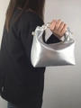 Close-up of metallic silver pillow bag featuring elegant white pearl handle and gold hardware - Silver