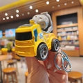 Detailed close-up of a mini yellow concrete mixer truck keychain with a metal ring - Cement Mixer