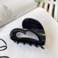 Détail d'une pince à cheveux noire élégante en forme de cœur sur un fond blanc épuré - Boucle Papillon Cœur Moyen (env. 6,5 cm) / Noir Brillant