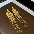 Dettaglio di orecchini a nappa dorata con motivi a foglia di grano su fondo scuro - Oro (Perno in Argento S925)