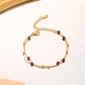 Macro detail of multilayer gold chain bracelet with garnet beads and lobster clasp closure - Gold (Bracelet)