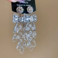 Detalle de pendientes de lazo plateado con flecos de cristal y botón de flor - Pendientes de botón con borla de gota de agua de cristal de mariposa en plata 925
