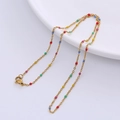 Close-up of golden O-chain necklace featuring multi-colored enamel beads details - Gold - Multicolor Beads