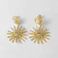 Detalle de pendientes de estrella dorada con perlas blancas y cristales de circonita - Estilo de Circonita de Estrella