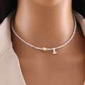 Collana di perle con cuore dorato e ciondolo lettera I bianca indossata dal modello - Lettera I