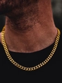 Close-up of a golden Cuban link necklace worn by a model with a dark focused background - Gold