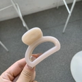 Close-up of a nude pink square claw clip with a glossy finish held in hand - Light Nude Pink