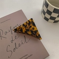 Gros plan d'une pince à cheveux triangulaire en écaille sur un livre et une tasse - Grand / Imprimé Léopard Foncé