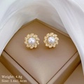 Golden flower earrings set with central pearl and zircon halo in elegant jewelry box - Gold Pearl Flower Stud Earrings