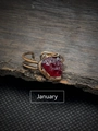 Macro shot of retro adjustable ring with raw red garnet stone on dark bark background - January - Garnet
