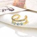 Macro shot of double-layer gold open ring with zircons and enamel evil eye details - Light Blue Eyes Style