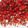 Macro detail of mixed red and gold glass seed beads for handmade DIY jewelry crafting - Red Series