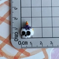 Detailed size view of a miniature resin skull bead with a purple candle and flame - Candle Skull