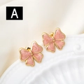 Golden bow stud earrings with pink marble texture on elegant white fabric and ceramic plate - Pink Marble Pattern