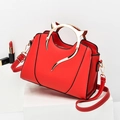 Chic red women's handbag with golden cat-ear metal handles and adjustable strap - Red