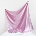 Detail view of pink satin square scarf with elegant draping on an open book - 90*90cm / Pink