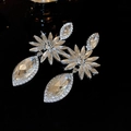 Primer plano de pendientes largos de flores con pedrería brillante y acabado plateado - Plata (Pin de plata)