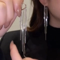 Close-up showing the elegant 8-10cm long silver heart tassel earrings worn on ear - Silver Hoop Long Tassel