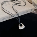 Macro shot of silver handbag pendant on layered black cord with a brushed metal finish - Black Rope Silver Bag Pendant